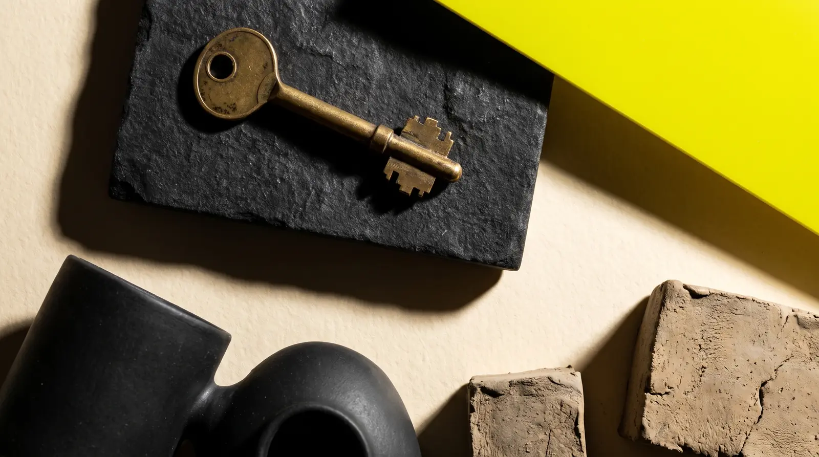 a single brass key on a dark slab